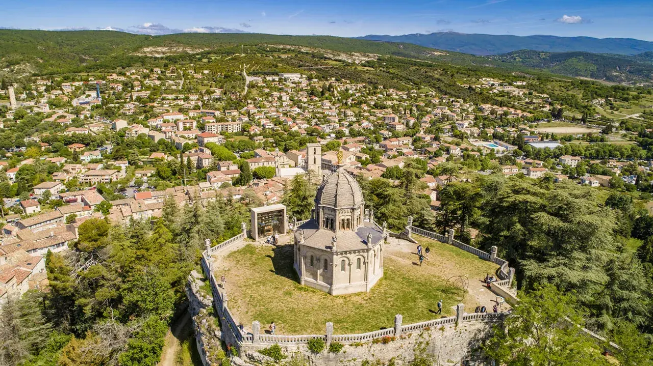 Vue aérienne de la citadelle de Forcalquier, avec son dôme imposant et le village pittoresque en arrière-plan.