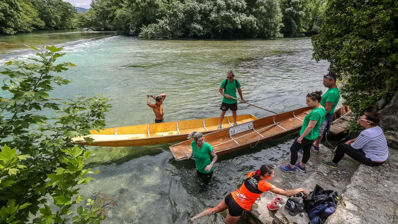Des gens préparent des barques en bois pour une balade sur la Sorgue, un moment de partage des eaux à L'Isle-sur-la-Sorgue.