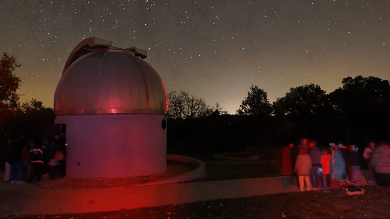 Nuit étoilée au saint michel l'observatoire. Un dôme d'observation et un groupe d'astronomes observent le ciel.