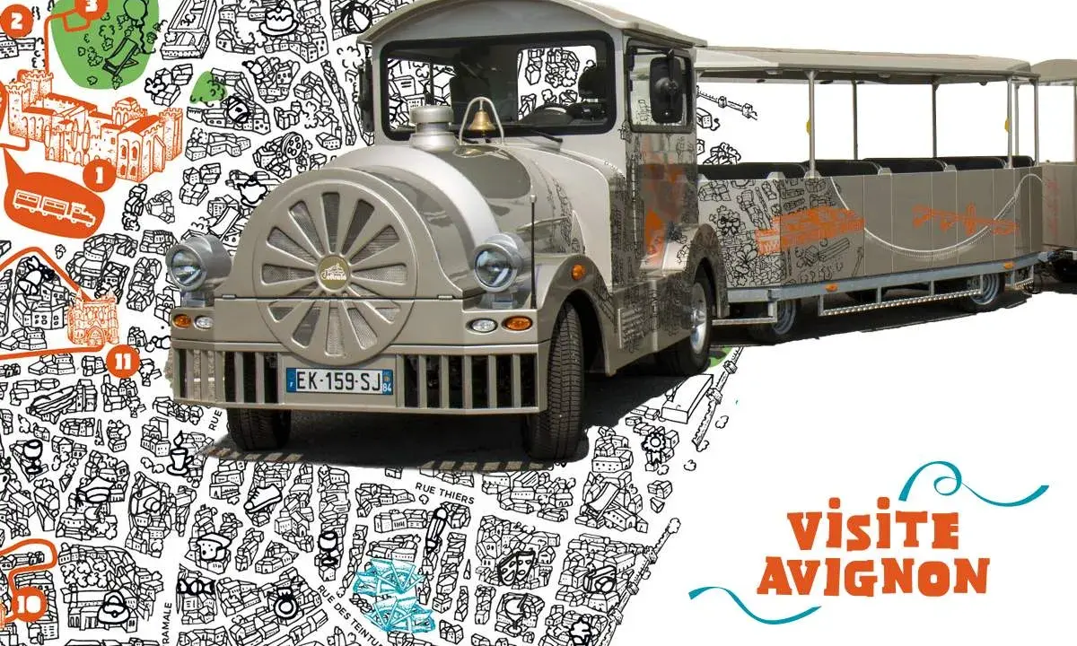 Le petit train touristique de Avignon, décoré de dessins de la ville, prêt à emmener les visiteurs découvrir les trésors d'Avignon.