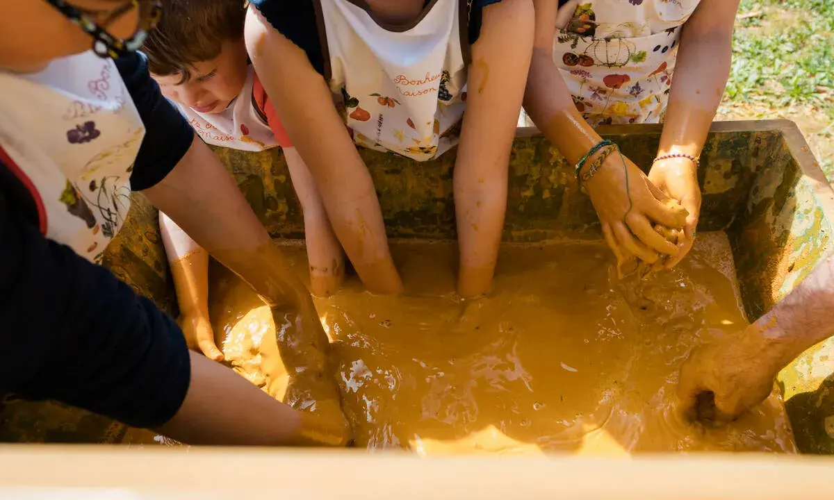 Des enfants s'amusent dans la boue, une super activité enfant Vaucluse pour explorer et créer.