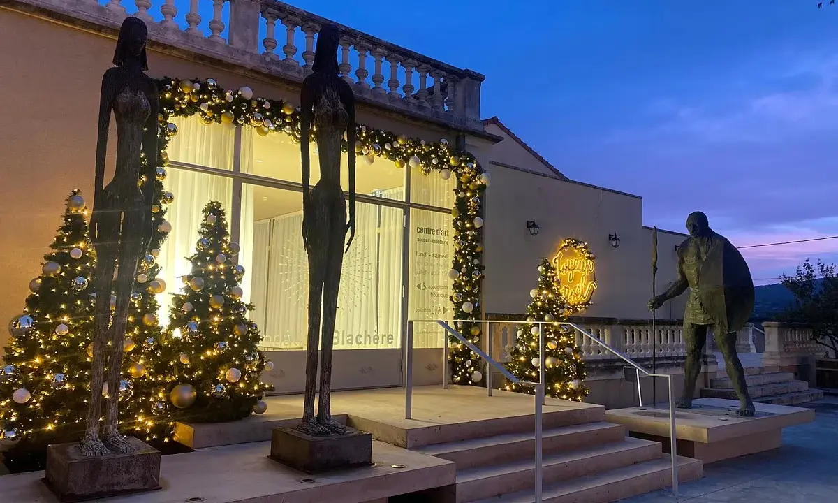 Sculptures et sapins illuminés devant la Fondation Blachère, ambiance festive au crépuscule.