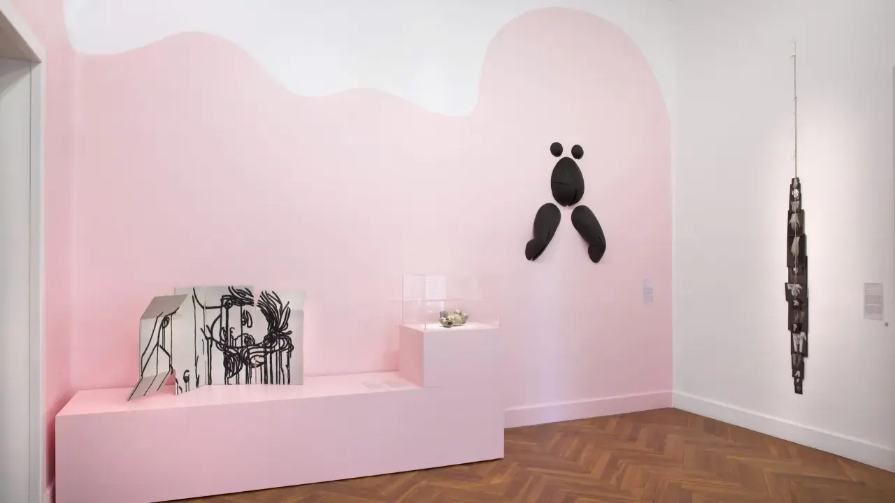 Exposition à la fondation Villa Datris : œuvres d'art contemporain sur fond rose, dont une sculpture abstraite noire et une installation de photos.