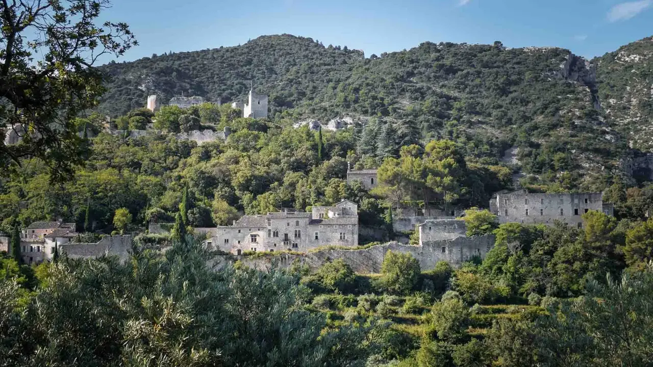 Vestiges de l'oppidum le Vieux, un village perché sur une colline verdoyante, baigné de soleil.