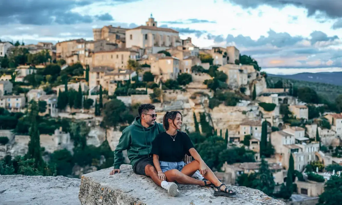 Couple en pause lors d'une randonnée à Gordes, profitant de la vue sur le village perché.