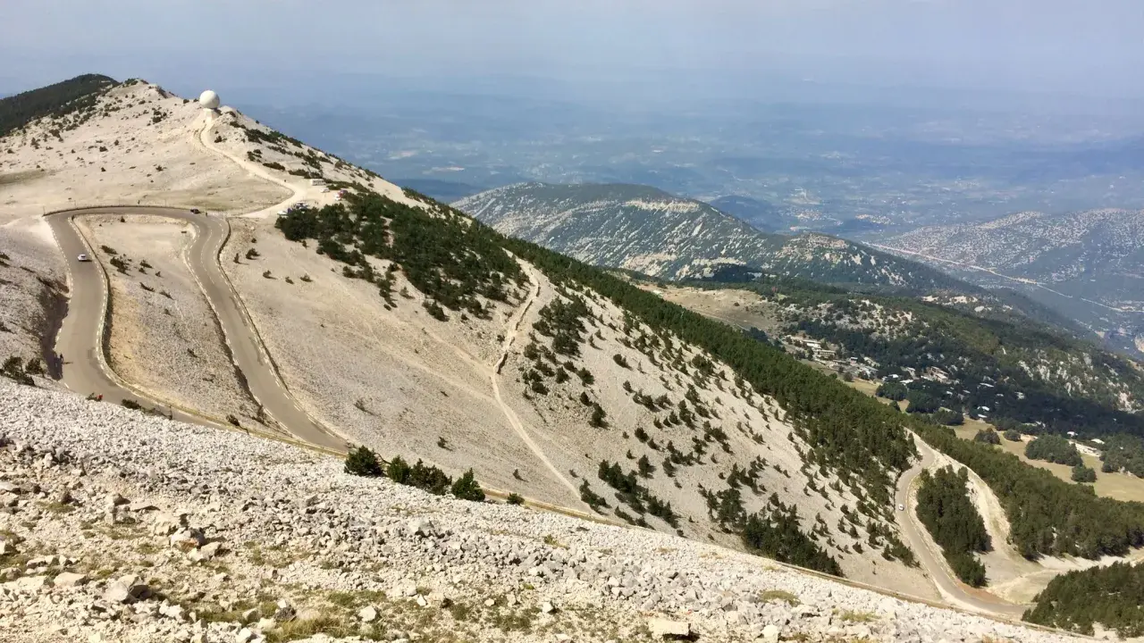Vue panoramique depuis le sommet du Mont Ventoux, avec ses routes sinueuses et les **villes sur Auze** lointaines.