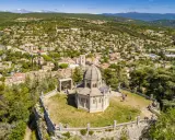 Vue aérienne de la citadelle de Forcalquier, avec son dôme imposant et le village pittoresque en arrière-plan.