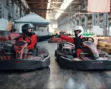 Deux pilotes en karts se donnent un fist bump, prêts pour une course de karting Vaucluse.