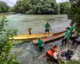 Des gens préparent des barques en bois pour une balade sur la Sorgue, un moment de partage des eaux à L'Isle-sur-la-Sorgue.