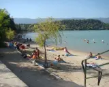 Plage animée à l'étang de la Bonde, baigneurs dans l'eau, familles sur le sable. Avis positif pour ce lieu de détente.