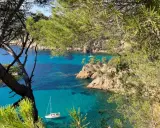 Vue sur la côte rocheuse et la mer turquoise de Bandol, avec des voiliers. Idéal pour savoir que faire à Bandol.