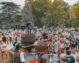 Foule joyeuse à Avignon pour le ban des vendanges, avec un pressoir à vin traditionnel au centre.