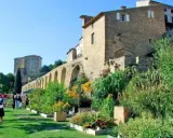 Jardin luxuriant devant le **château de Lauris**, avec ses murs de pierre et ses arches médiévales.