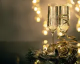 Deux flûtes de champagne pétillant, décorées de rubans dorés, prêtes pour le nouvel an à Avignon. Lumières festives en arrière-plan.