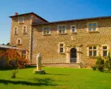 Statue de la Vierge devant la façade en pierre de la blauvac abbaye, sous un ciel bleu éclatant.