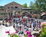Foule en costume d'époque lors de la fête de la veraison, avec des musiciens et des stands.