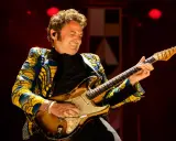 Un guitariste exprime sa passion sur scène, un moment vibrant de la Fête de la Musique à Carpentras.