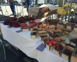 Au marché de Carpentras, des piments rouges vifs et des poivrons colorés sont présentés dans des paniers en bois.