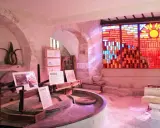 Dans le musée du vitrail Gordes, une roue de moulin ancienne côtoie un vitrail éclatant de soleil et de couleurs chaudes.