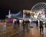 Un marché de Noël illuminé à Vaucluse, avec une grande roue et des chalets festifs.