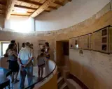Visite du moulin de Salignan, un groupe découvre les panneaux d'exposition dans l'espace circulaire aux murs de pierre.
