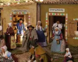 Scène de village provençal avec santons. Découvrez les plus belles crèches de Noël en Provence, avec des personnages costumés devant le grainetier et l'apothicaire.