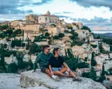 Couple en pause lors d'une randonnée à Gordes, profitant de la vue sur le village perché.
