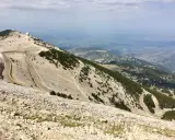 Vue panoramique depuis le sommet du Mont Ventoux, avec ses routes sinueuses et les **villes sur Auze** lointaines.
