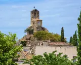 La tour de l'église de Lourmarin, perchée sur une colline rocheuse, domine le village. Un cadran solaire orne son flanc.