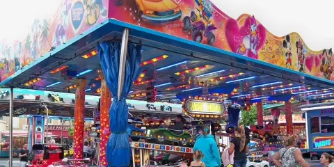 Attraction for children with cars, decorated with Mickey Mouse and friends. A sign says "Paris Dakar".