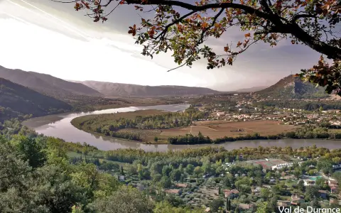 Vue panoramique d'une vallée avec une rivière sinueuse, des vignobles et un village. Idéal pour une randonnée à Pertuis.