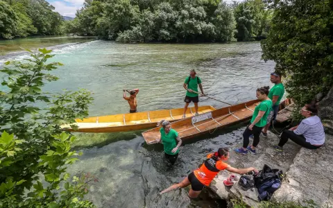 Des gens préparent des barques en bois pour une balade sur la Sorgue, un moment de partage des eaux à L'Isle-sur-la-Sorgue.