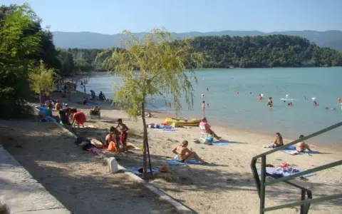Plage animée à l'étang de la Bonde, baigneurs dans l'eau, familles sur le sable. Avis positif pour ce lieu de détente.