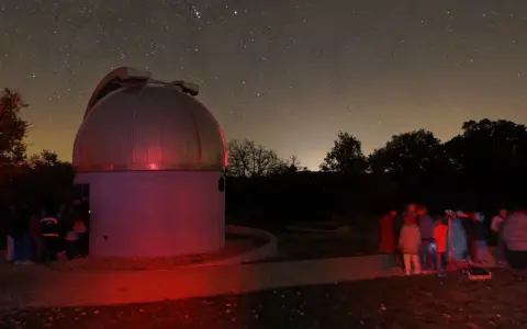 Nuit étoilée au saint michel l'observatoire. Un dôme d'observation et un groupe d'astronomes observent le ciel.