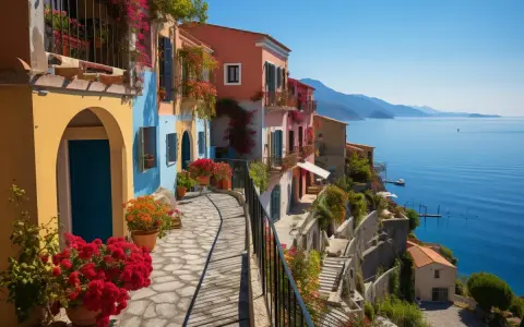 Un chemin pavé serpente entre des maisons colorées fleuries, dominant la mer bleue. Un aperçu des plus beaux villages autour de Cassis.