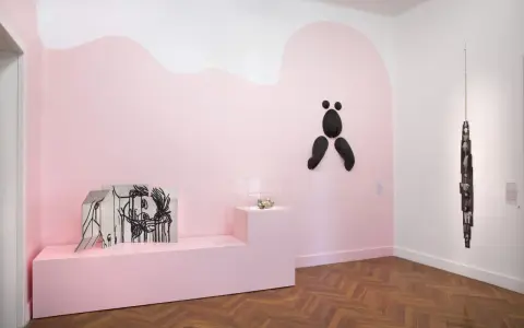Exposition à la fondation Villa Datris : œuvres d'art contemporain sur fond rose, dont une sculpture abstraite noire et une installation de photos.
