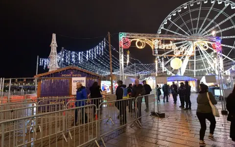 Un marché de Noël illuminé à Vaucluse, avec une grande roue et des chalets festifs.