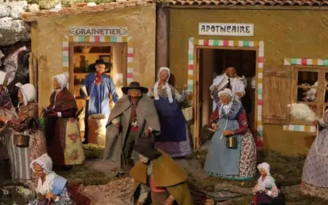 Scène de village provençal avec santons. Découvrez les plus belles crèches de Noël en Provence, avec des personnages costumés devant le grainetier et l'apothicaire.