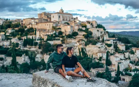 Couple en pause lors d'une randonnée à Gordes, profitant de la vue sur le village perché.