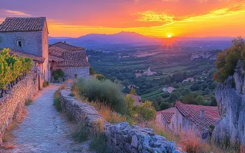 Coucher de soleil sur un village perché de Saignon, France. La lumière dorée baigne les maisons de pierre et la vallée verdoyante.