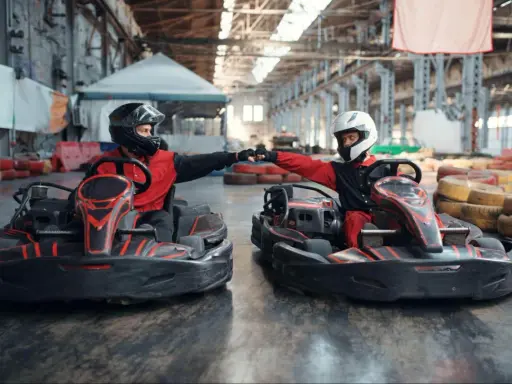 Deux pilotes en karts se donnent un fist bump, prêts pour une course de karting Vaucluse.