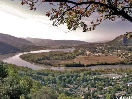 Vue panoramique d'une vallée avec une rivière sinueuse, des vignobles et un village. Idéal pour une randonnée à Pertuis.