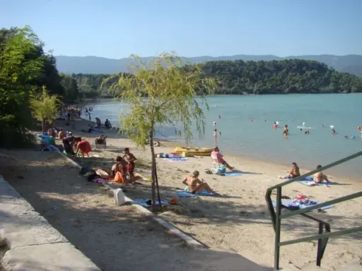 Plage animée à l'étang de la Bonde, baigneurs dans l'eau, familles sur le sable. Avis positif pour ce lieu de détente.