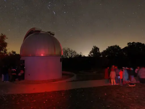 Nuit étoilée au saint michel l'observatoire. Un dôme d'observation et un groupe d'astronomes observent le ciel.