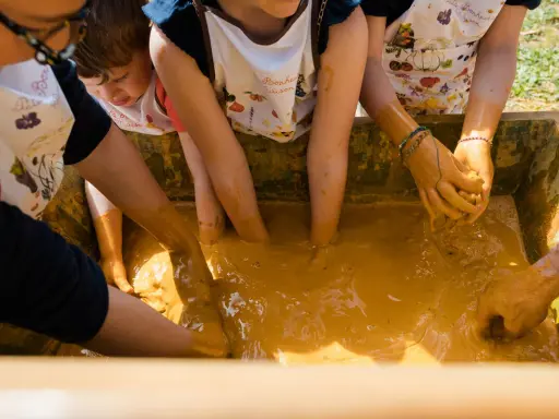Des enfants s'amusent dans la boue, une super activité enfant Vaucluse pour explorer et créer.