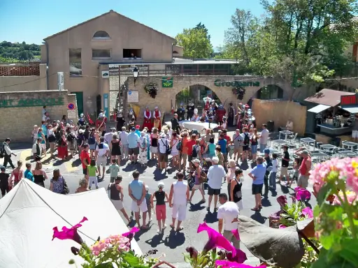 Foule en costume d'époque lors de la fête de la veraison, avec des musiciens et des stands.