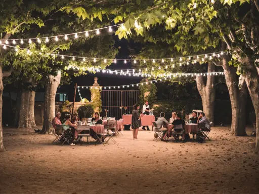 Soirée d'été en Provence sous les guirlandes lumineuses. Un dîner en plein air, parfait pour l'agenda des manifestations en Provence.