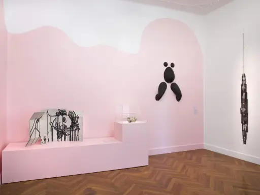 Exposition à la fondation Villa Datris : œuvres d'art contemporain sur fond rose, dont une sculpture abstraite noire et une installation de photos.