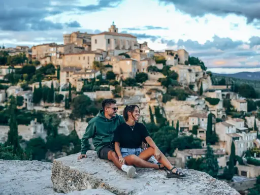 Couple en pause lors d'une randonnée à Gordes, profitant de la vue sur le village perché.
