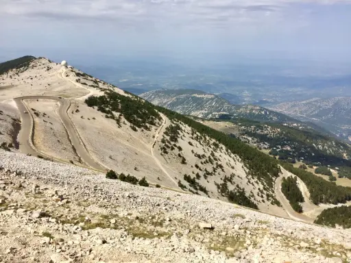 Vue panoramique depuis le sommet du Mont Ventoux, avec ses routes sinueuses et les **villes sur Auze** lointaines.